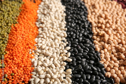Fotografie Composition with different raw legumes as background