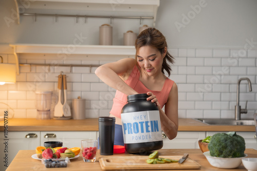 Photos Asian woman scooping whey protein powder into shaker bottle and healthy vegetabl