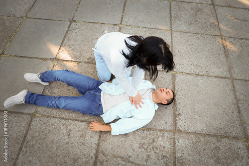 Young woman doing CPR to un...