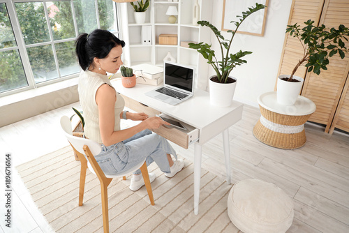 Young woman taking tablet c...
