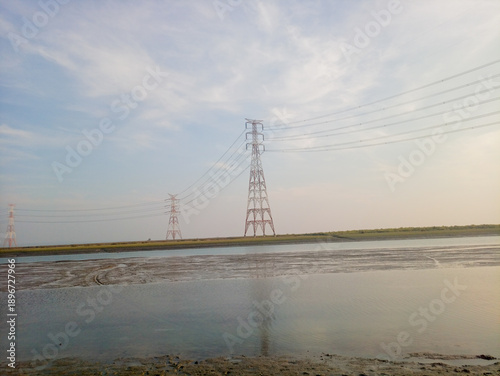 Electrical Transmission Towers and Power Lines Over Coastal Wetland at Dusk