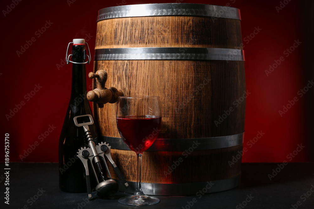 Fototapeta premium Wooden barrel, corkscrew, bottle and glass of wine on dark background
