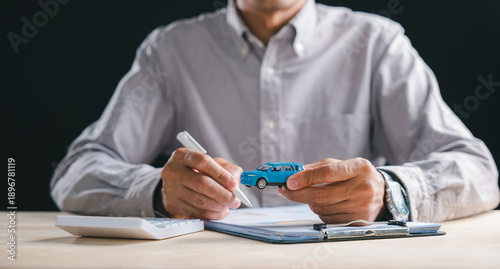 Foto Person holding auto model prepares to sign car contract loan document for financ