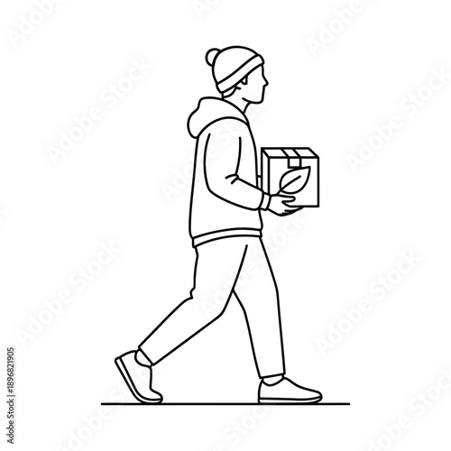 Casual delivery person in hoodie and beanie carrying a branded box while walking outdoors