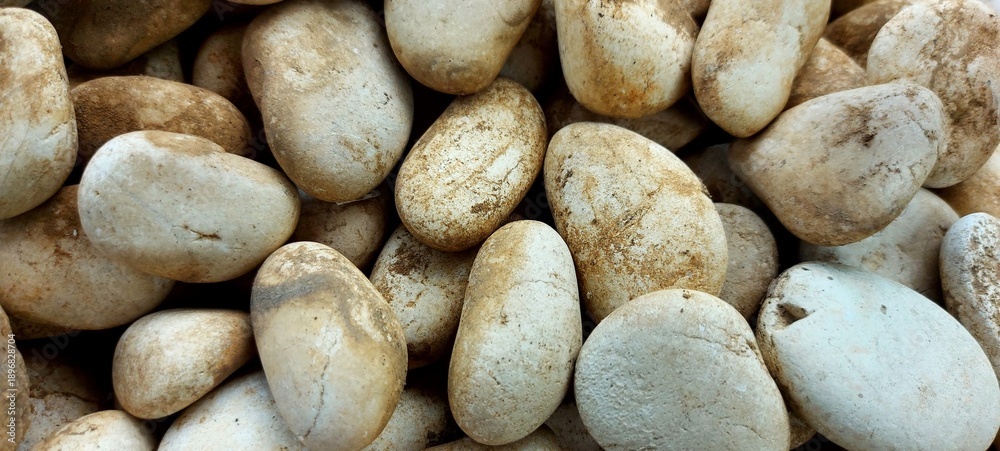 Fototapeta premium Close-Up of Smooth River Pebbles with Earthy Tones