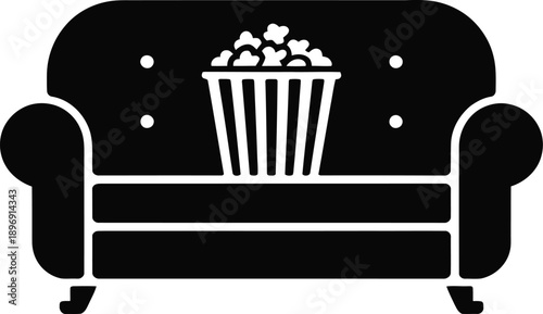 A black silhouette of a comfortable tufted sofa with a full popcorn bucket centered on top.