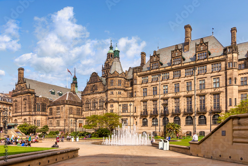 Sheffield Town Hall and Peace Gardens on a sunny spring day, people relaxing in the square, fountain playing, beautiful.