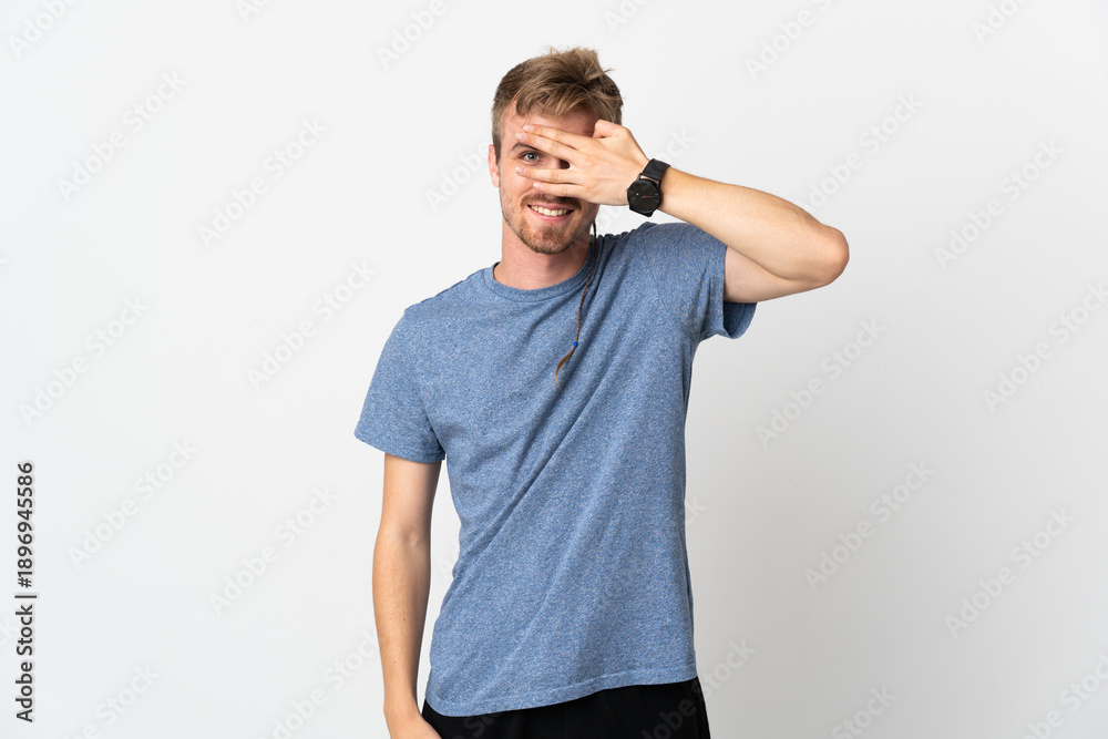 Fototapeta premium Young handsome man isolated on white background covering eyes by hands and smiling