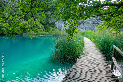 Cuadro en lienzo Empty boardwalk runs past an emerald lake in the scenic Plitvice national park