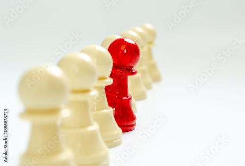 Standing red pawn breaking formation representing speaking up.