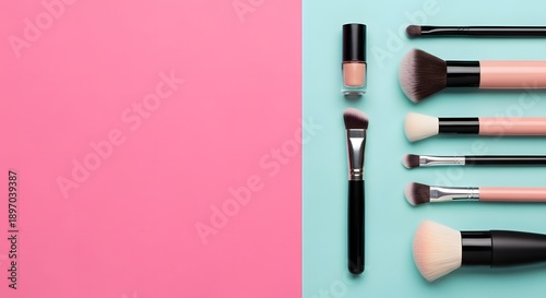 Flat lay composition of various cosmetic makeup brushes and a small nude nail polish bottle on a split pastel pink and aqua background with copy space.