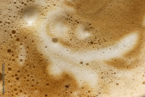 Happy coffee foam latte art in cappuccino beverage. close up brown morning drink with smiling face pattern. An abstract, frothy texture, pleasant cheerful surprise