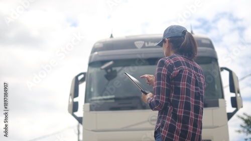 Photography Female truck driver holding digital tablet, managing logistics and tracking carg