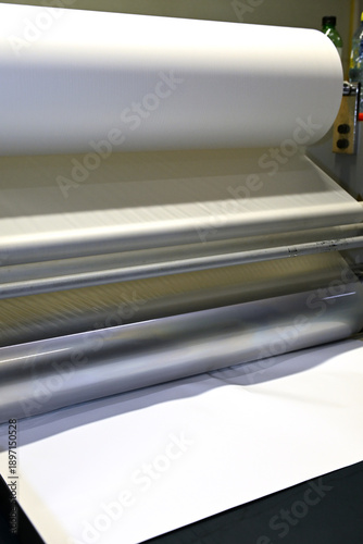 Fotografie Work behind the laminator in the production shop of the printing house