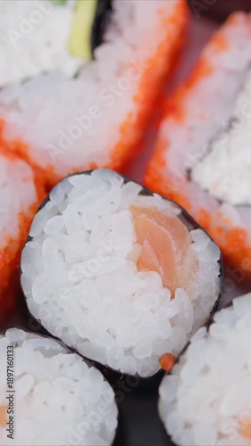 Bright studio setting with meticulously arranged fresh sushi pieces. Chef carefully organizes array of colorful maki and uramaki sushi slices in welllit studio environment