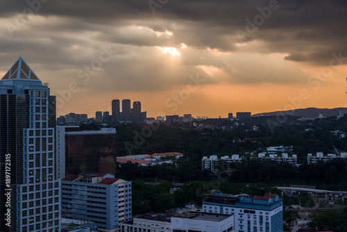 Photography Dramatic sunset clouds with sun rays beaming down over Kuala Lumpur city skyline
