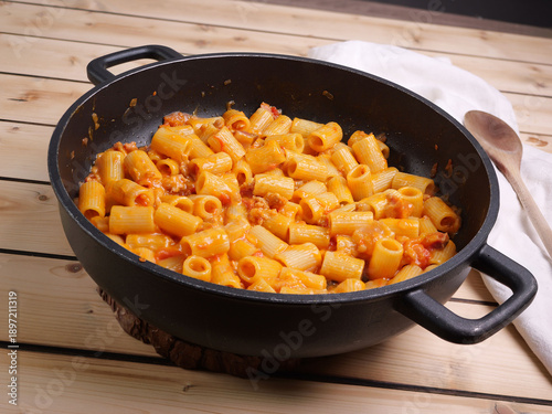 Pentola con pasta al sugo di pomodoro guanciale e salsicccia