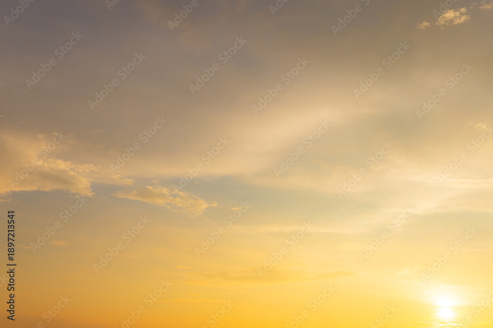 Fototapeta premium Beautiful sunset sky with soft orange and purple clouds background,Panoramic view of dramatic evening sky during sunset. Vibrant orange light on the horizon blending with soft purple and blue tones.
