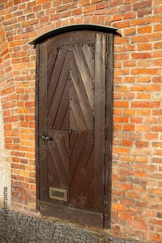 Old wooden door in historic brick wall