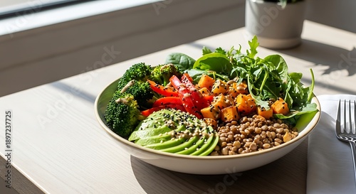 Healthy salad bowl with avocado greens and grains on a table