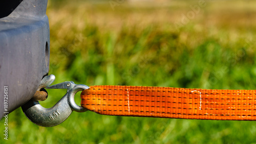 Tow hook with orange strap on car. Towing equipment.