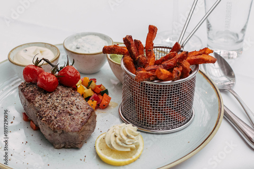 Süßkartoffelpommes mit Steak auf Teller