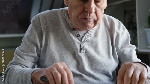 Happy senior man eating a scramble on a white plate with vegetables. Elderly male using knife and fork to cutting meal, has a breakfast. Balanced diet, cooking, culinary. Food concept. Old person