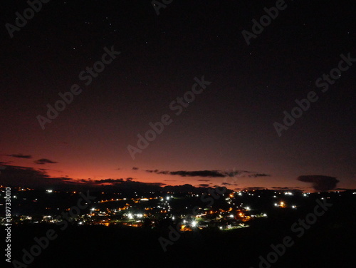 City at dusk with lights on and dark sky