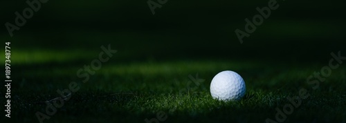Golf ball on golf course near hole with flagstick in morning sunshine. view from above, close up, 