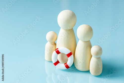 Help for families. Social concept. Wooden figurines symbolizing a family with children and a lifesaver. Assistance programs and government support for large families