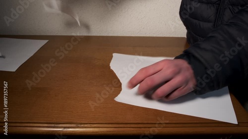Angry man tearing white paper into pieces