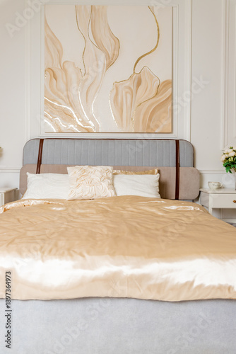 Pastel and beige bedding, soft pillows and fur coverlet. coziness, comfort, interior, holidays.luxury bedroom. Classical interior of beige bedroom with king size bed, pillows, plant and a plaid.
