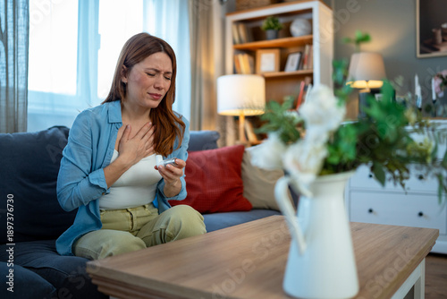 Foto Woman experiencing breathing difficulty using asthma inhaler at home