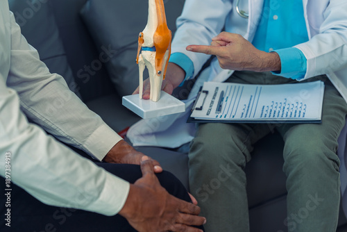 Canvas Print The doctor is providing consultation and treatment for a patient with knee pain, using a bone model, and also recommending preventive measures and health care to alleviate knee pain