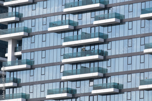 Contemporary Dubai architecture, residential buildings. Dubai skyscrapers where people live. Windows, balconies, and houses made of glass and concrete.