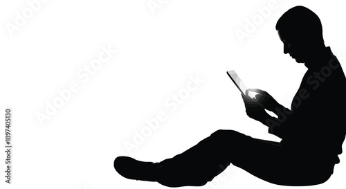 Silhouette of a person sitting while interacting with a glowing digital tablet device against white background