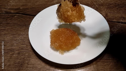 The chef puts red caviar on a plate