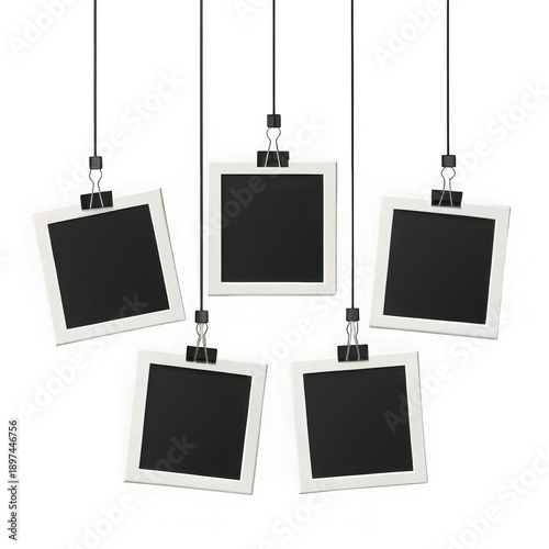 Five empty polaroid photo frames hanging from strings with clips on a solid black background