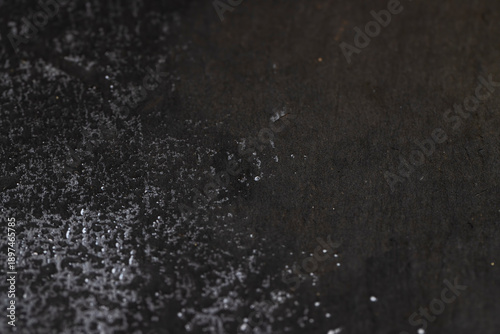 Fotografie wet black uneven and embossed black slate for serving, covered with lots of wate