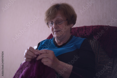 Elderly woman knitting in a chair