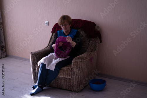 Elderly woman knitting in a chair