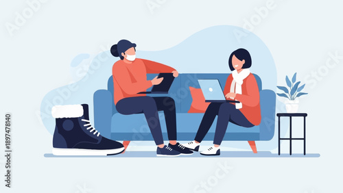 Two people work on laptops while sitting on a sofa, a boot nearby