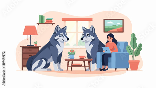 Two wolves sit in a cozy room with a woman using a laptop