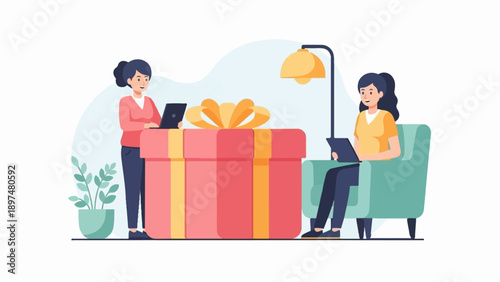 Two women are working on laptops near a large gift box