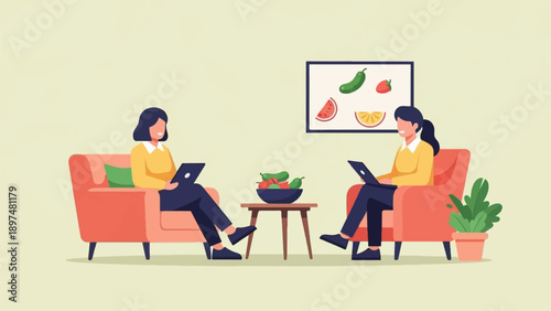Two women sit in armchairs on their laptops, with fruit on a table
