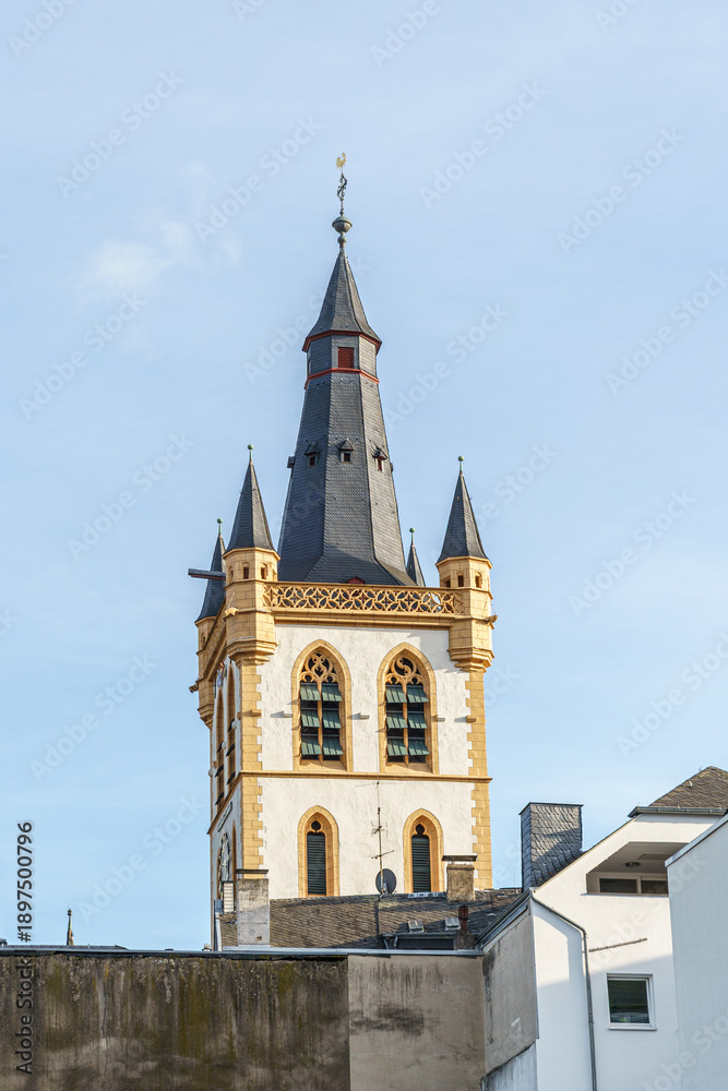 Obraz premium A square tower with a pointed black roof in the city of Trier, Germany There is a cross on the top of the tower, not a rooster