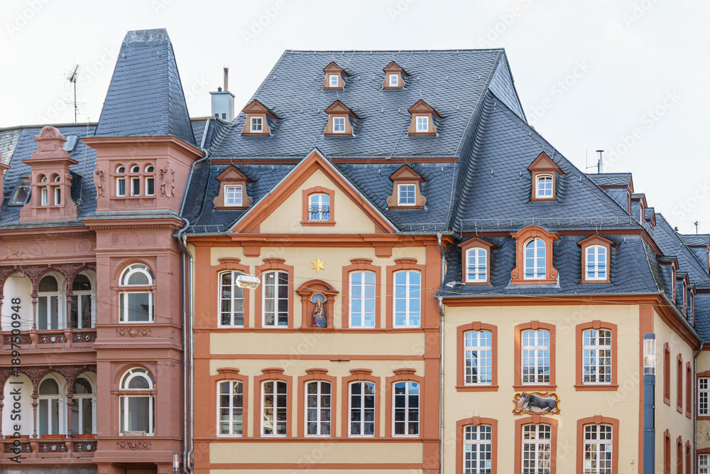 Fototapeta premium A row of buildings with a large one in the middle in Trier Germany. The building in the middle has a large window and a star on it