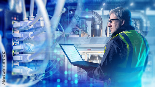 Photos Industrial automation, engineer monitors equipment and network connections on a laptop, supervising smart manufacturing systems, data flow, and technical maintenance