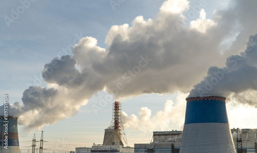 Factory chimney fumes emitting pollution to the atmosphere. CO2 and greenhouse gases emissions. The chimney emits exhaust gases into the blue sky. The concept of air pollution and the environment.	