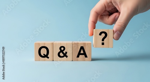 Hand places question mark block next to Q and A wooden blocks question and answer